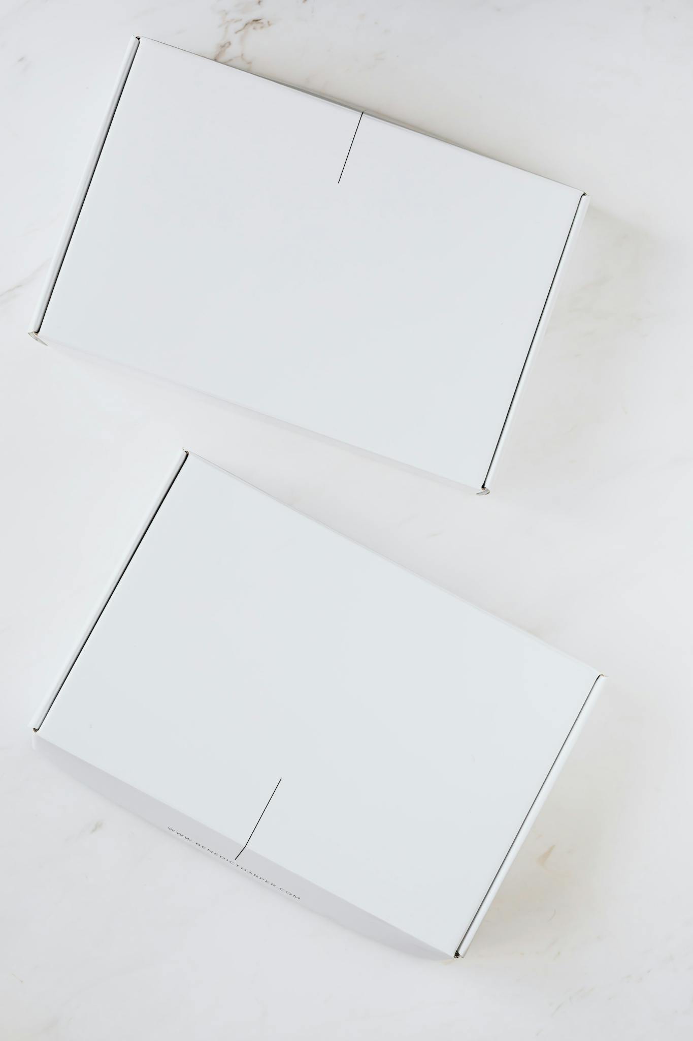 Two simple white boxes on a clean marble background. Ideal for product mockups.